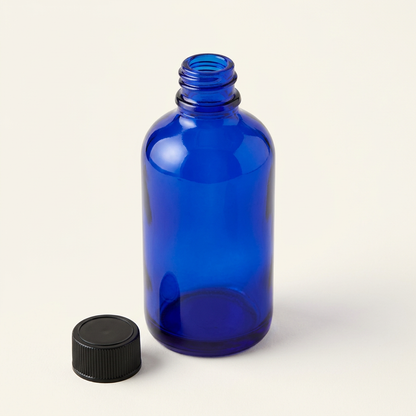 100 mL blue glass pharmacy bottle with cap removed and placed beside it
