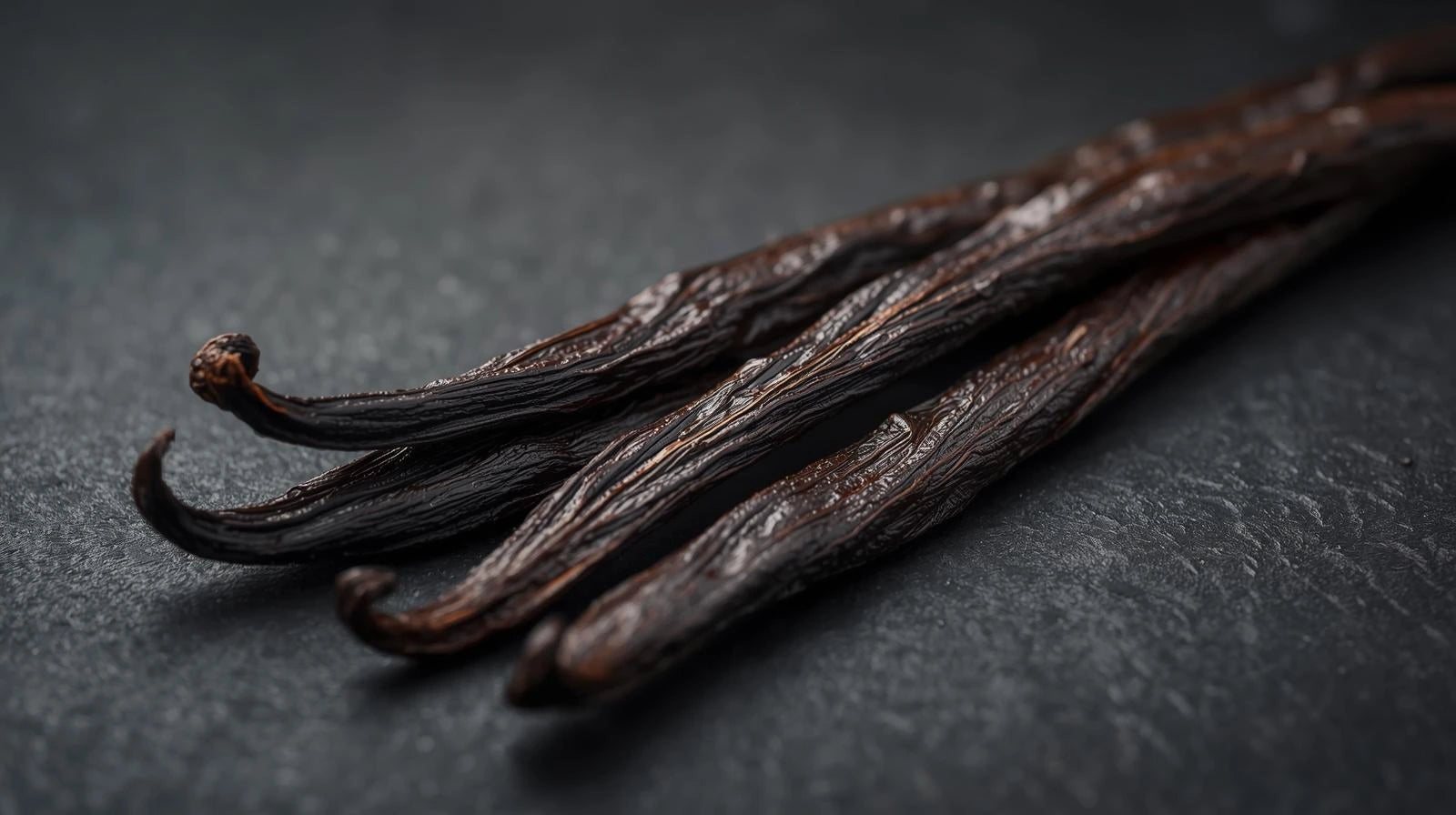 Close-up of vanilla beans on a dark surface